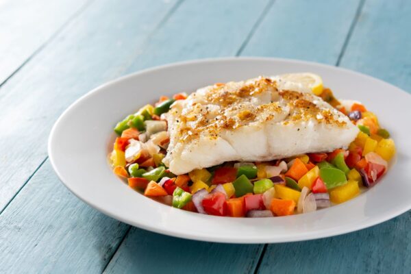 grilled-cod-with-vegetables-blue-wooden-table